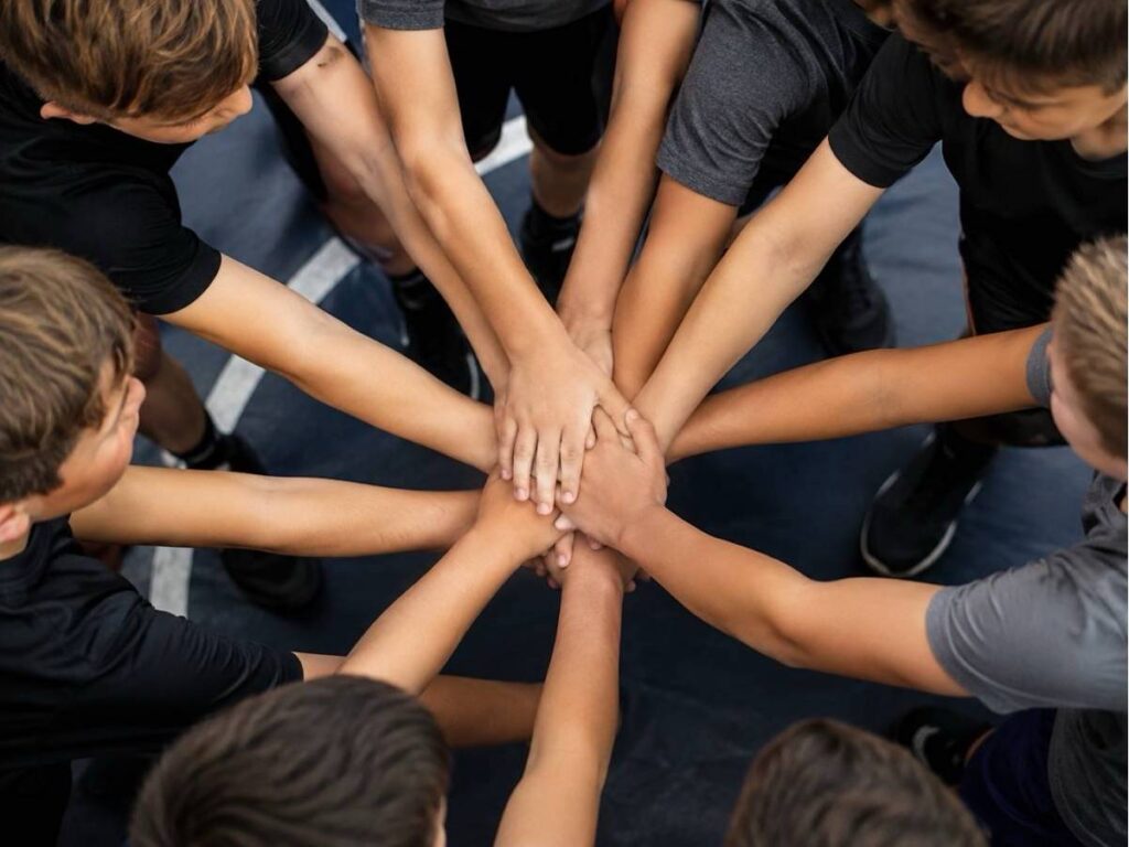Youth wrestling athletes placing their hands together in a team huddle